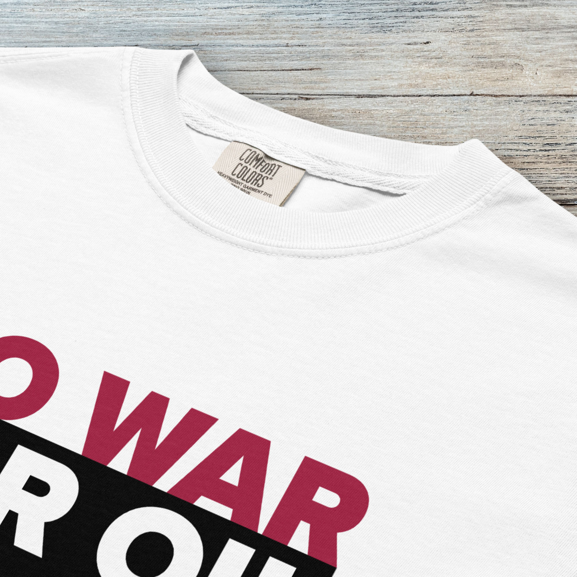 Closeup detail of white protest t-shirt with bold text reading “No War for Oil” and dripping oil graphic, anti-war political shirt.
