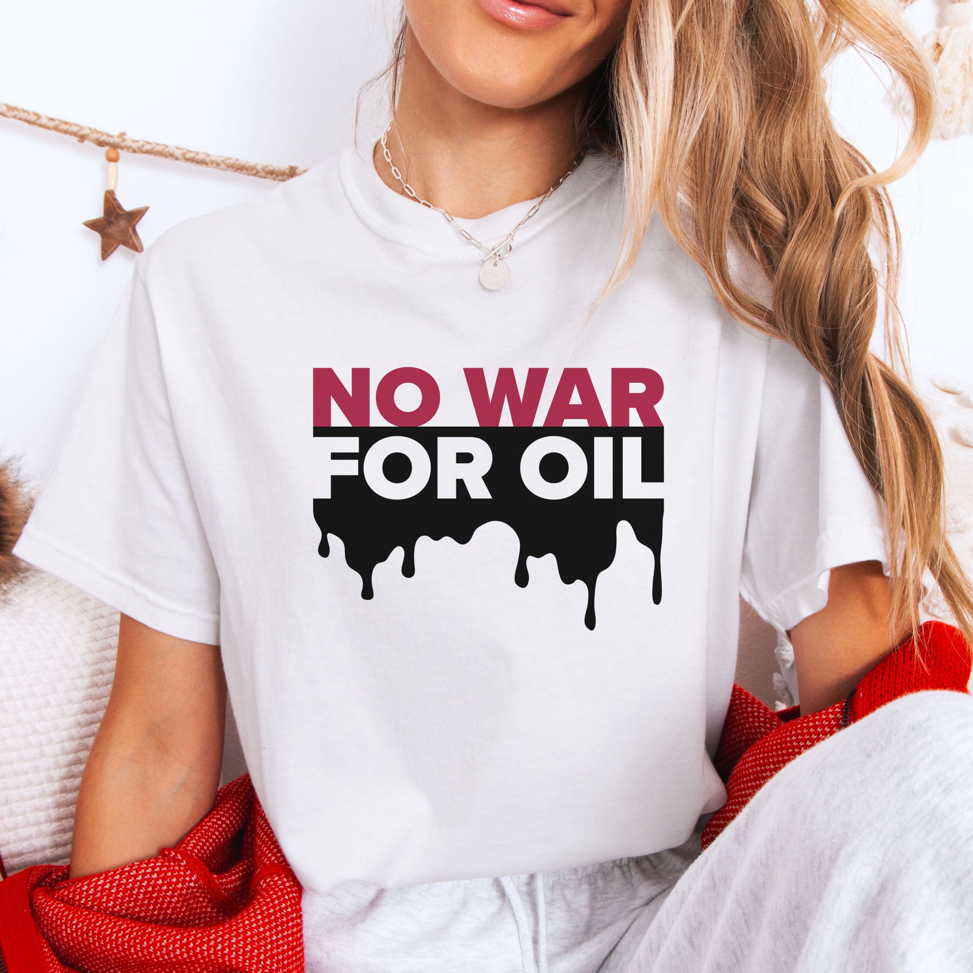 Female model wearing white protest t-shirt with bold text reading “No War for Oil” and dripping oil graphic, anti-war political shirt.