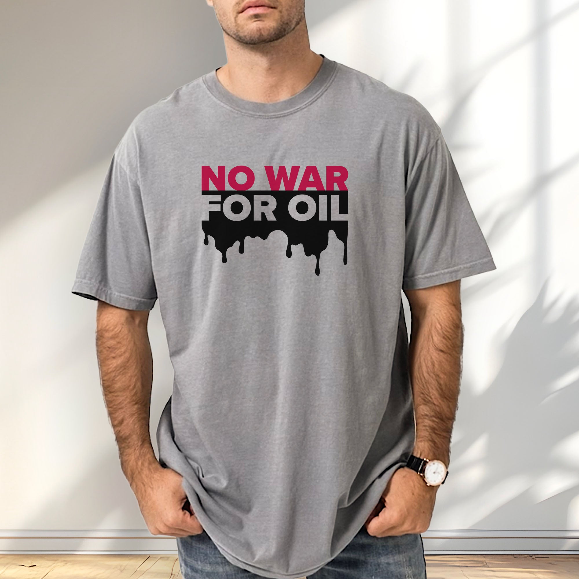 Male model wearing grey protest t-shirt with bold text reading “No War for Oil” and dripping oil graphic, anti-war political shirt.