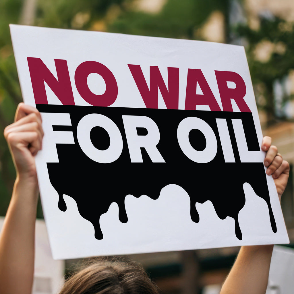Person holding high a protest sign reading “No War for Oil” in bold red and white letters with dripping oil graphic, criticizing oil-driven wars and U.S. military intervention.