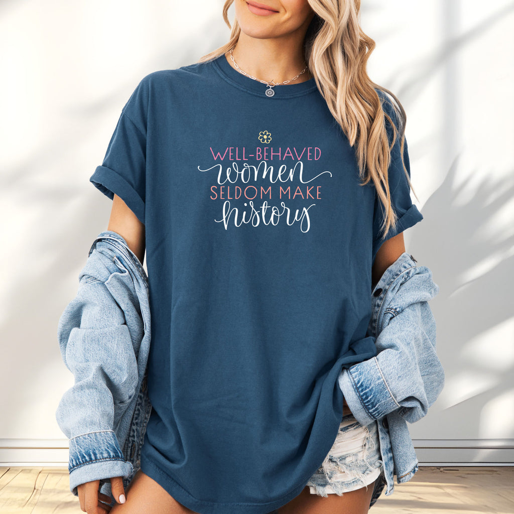 Female model wearing midnight feminist t-shirt with colorful text that reads “Well-behaved women seldom make history” — empowering women’s rights shirt and activist apparel.
