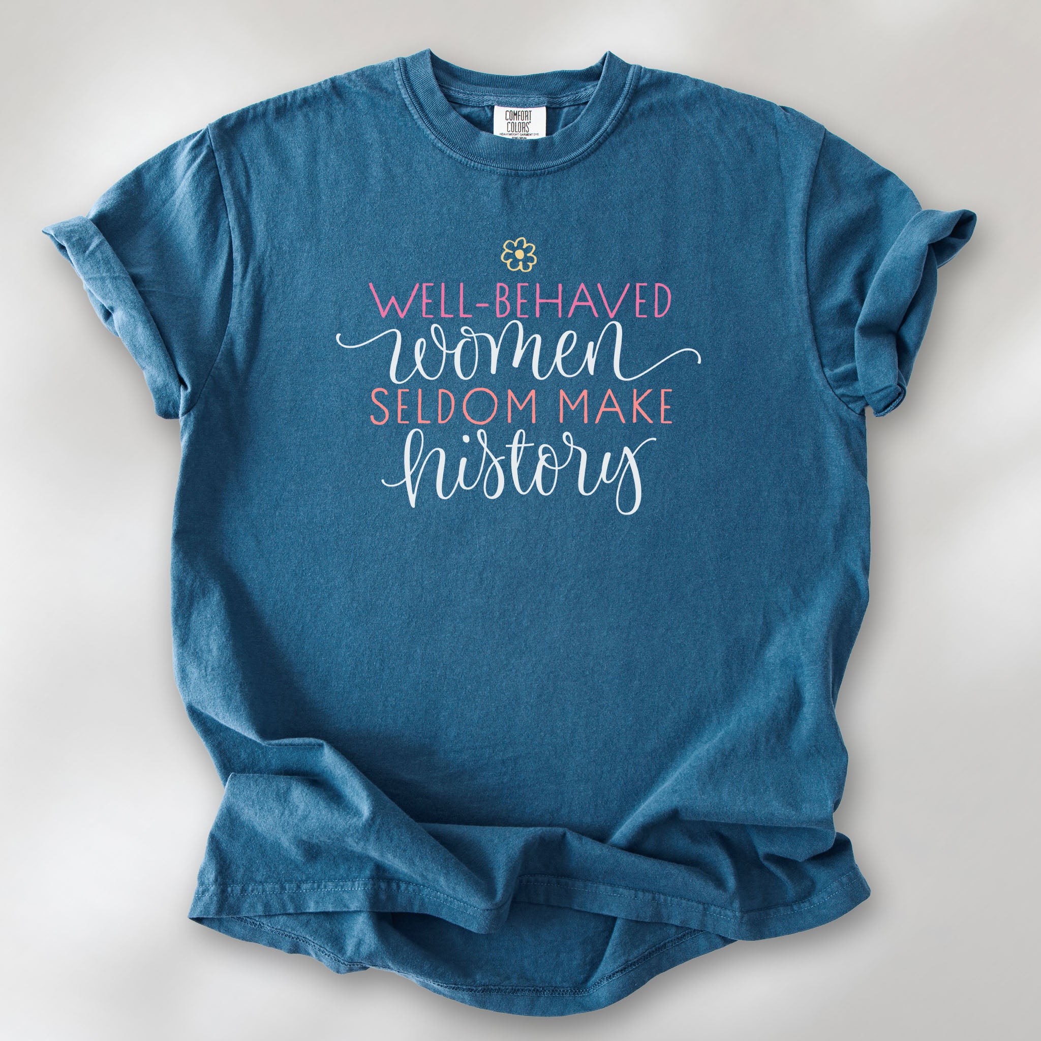 Midnight feminist t-shirt with colorful text that reads “Well-behaved women seldom make history” — empowering women’s rights shirt and activist apparel.