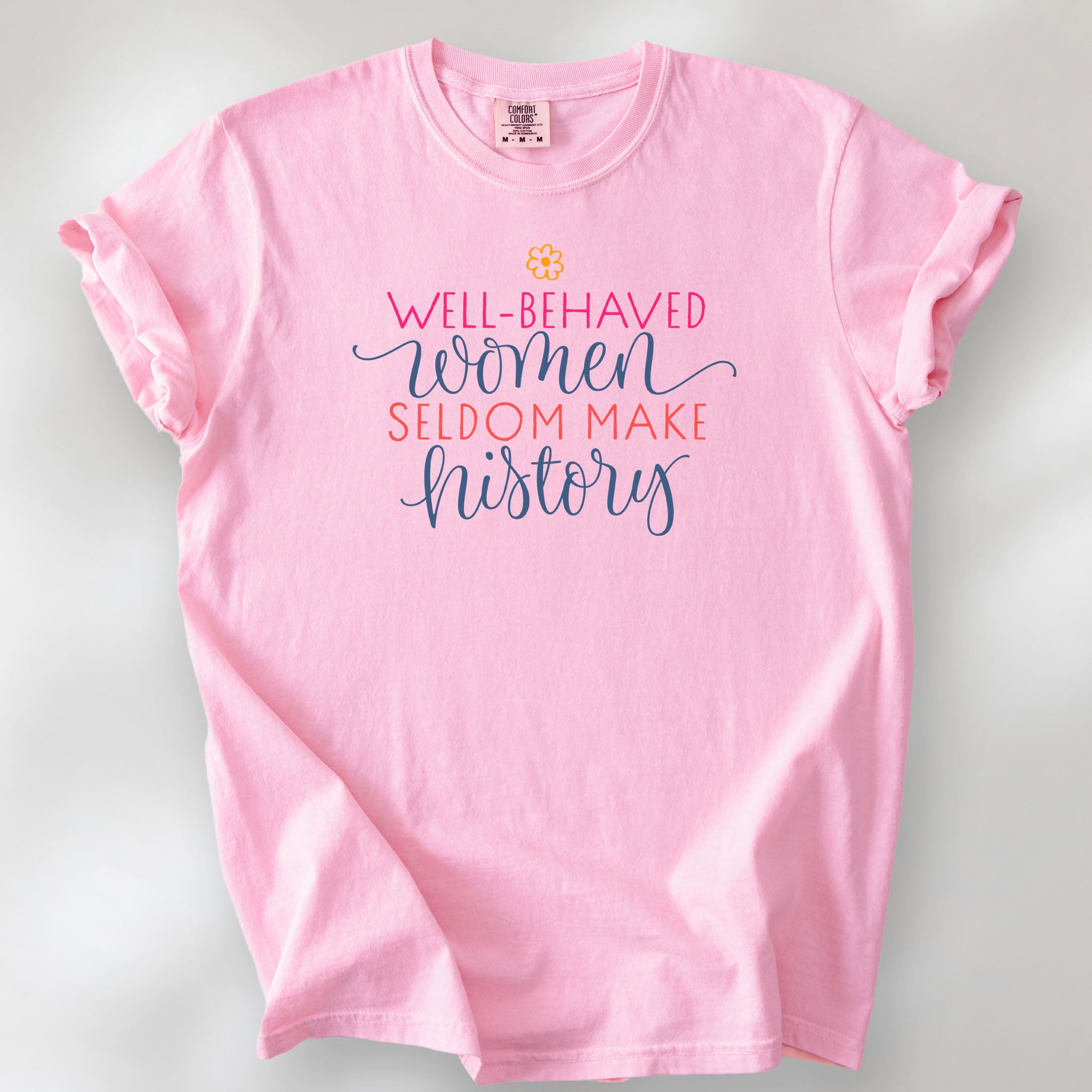 Blossom feminist t-shirt with colorful text that reads “Well-behaved women seldom make history” — empowering women’s rights shirt and activist apparel.