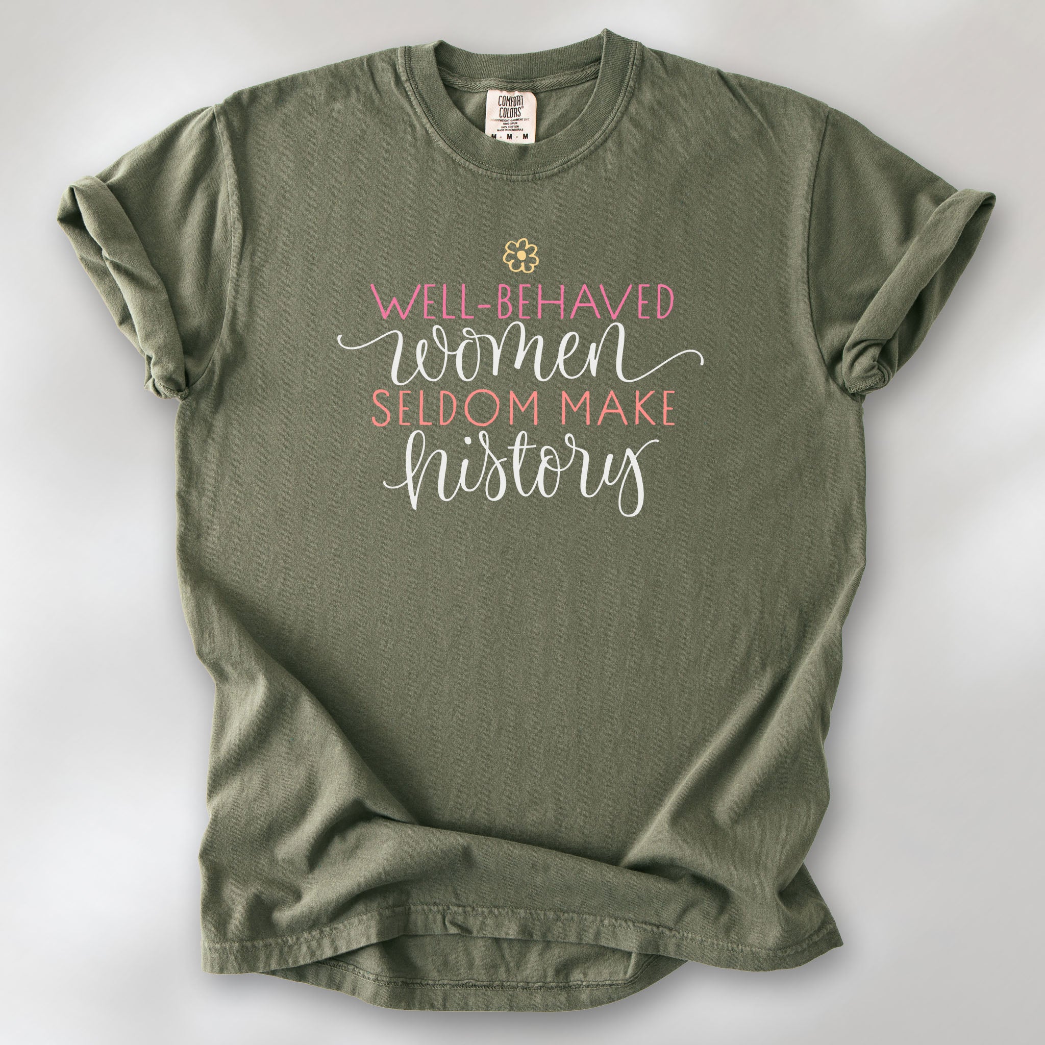 Sage feminist t-shirt with colorful text that reads “Well-behaved women seldom make history” — empowering women’s rights shirt and activist apparel.