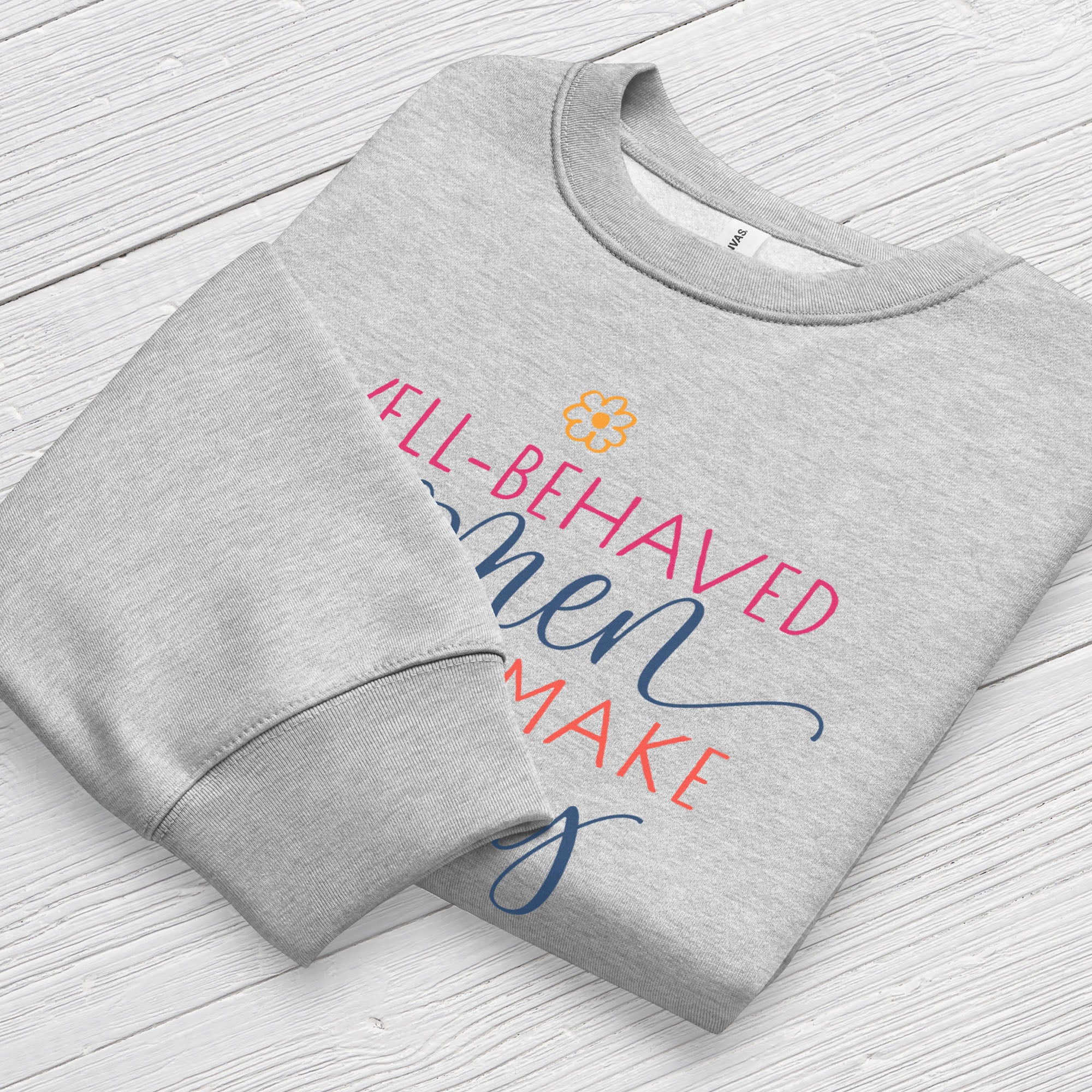 Folded athletic heather grey crewneck sweatshirt with stylized text graphic that reads "well-behaved women seldom make history",  displaying neck and sleeve cuffs.