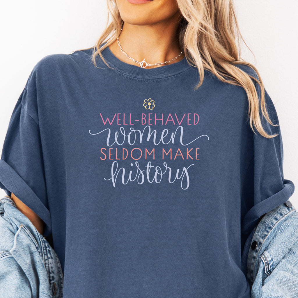 Female model wearing oversized denim t-shirt with graphic styled text that reads "well-behaved women seldom make history."