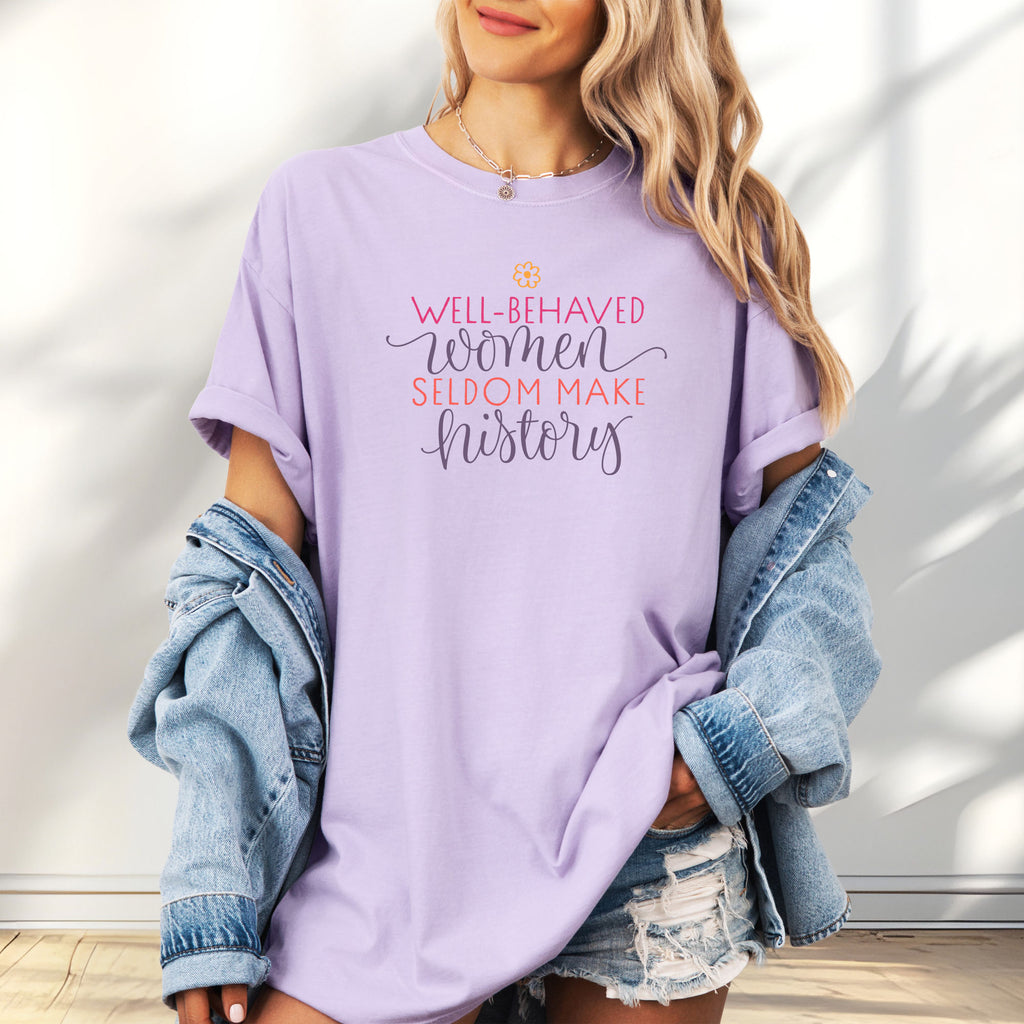 Female model wearing oversized orchid t-shirt with graphic styled text that reads "well-behaved women seldom make history."