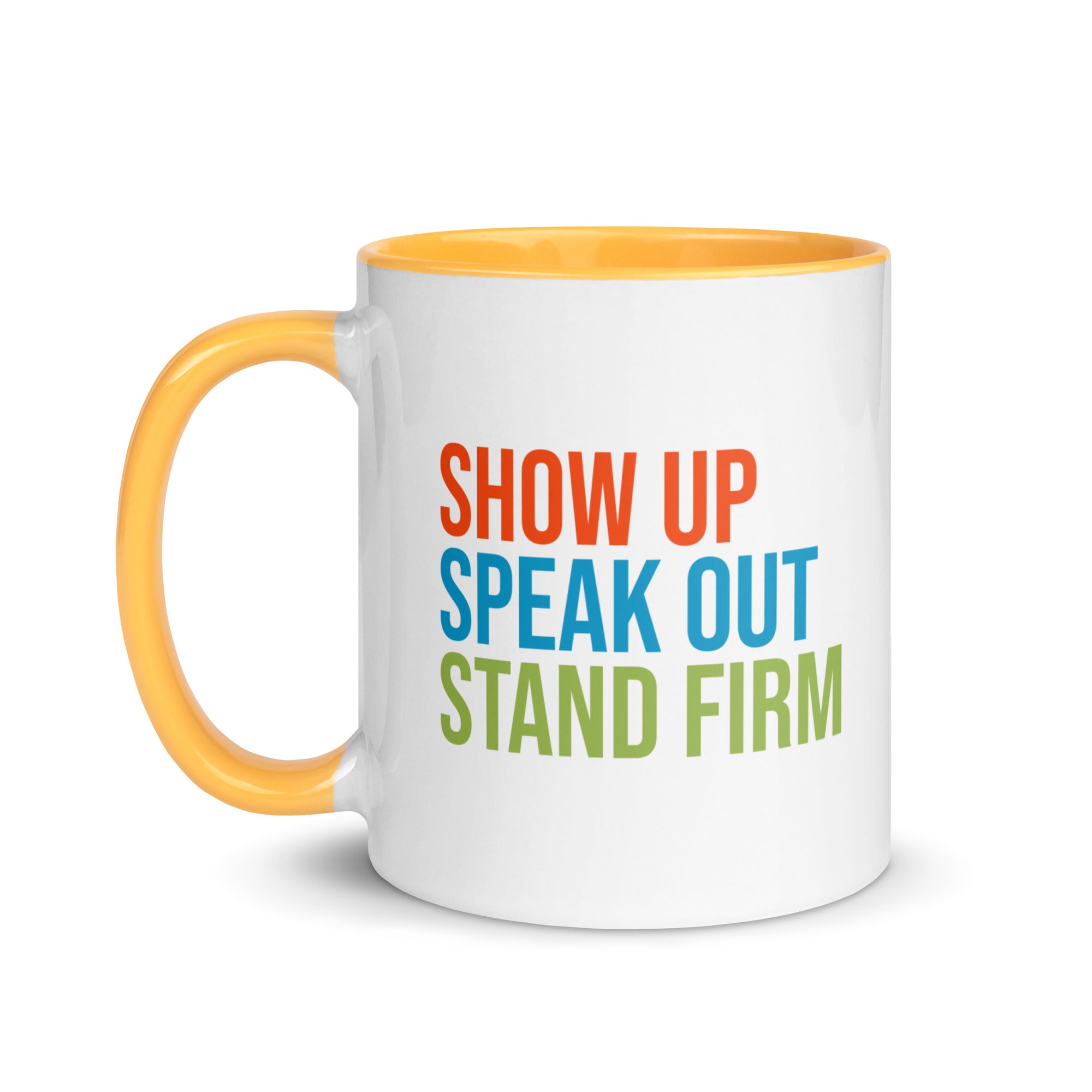 Coffee mug with bright gold handle and inside with text on one side that reads "show up, speak out, stand firm." The other side, not shown in photo, reads "democracy doesn't defend itself."