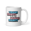11 ounce white ceramic mug with bold text “Trans Rights Are Human Rights” in blue, pink, and black colors representing the transgender pride flag.