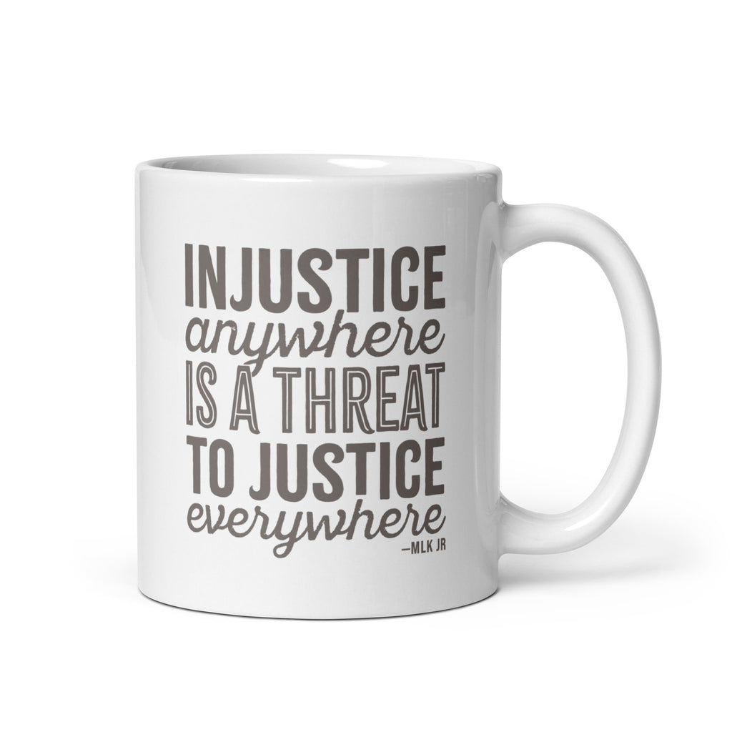 11 ounce white ceramic mug with bold text graphic reading “injustice anywhere is a threat to justice everywhere,” a quote from MLK Junior from Letters from Birmingham Jail.
