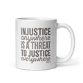 11 ounce white ceramic mug with bold text graphic reading “injustice anywhere is a threat to justice everywhere,” a quote from MLK Junior from Letters from Birmingham Jail.