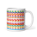 11 ounce coffee mug with a repeating hidden “love is love” message in the Gilbert font, featuring bright rainbow-inspired patterns wrapped around the mug.