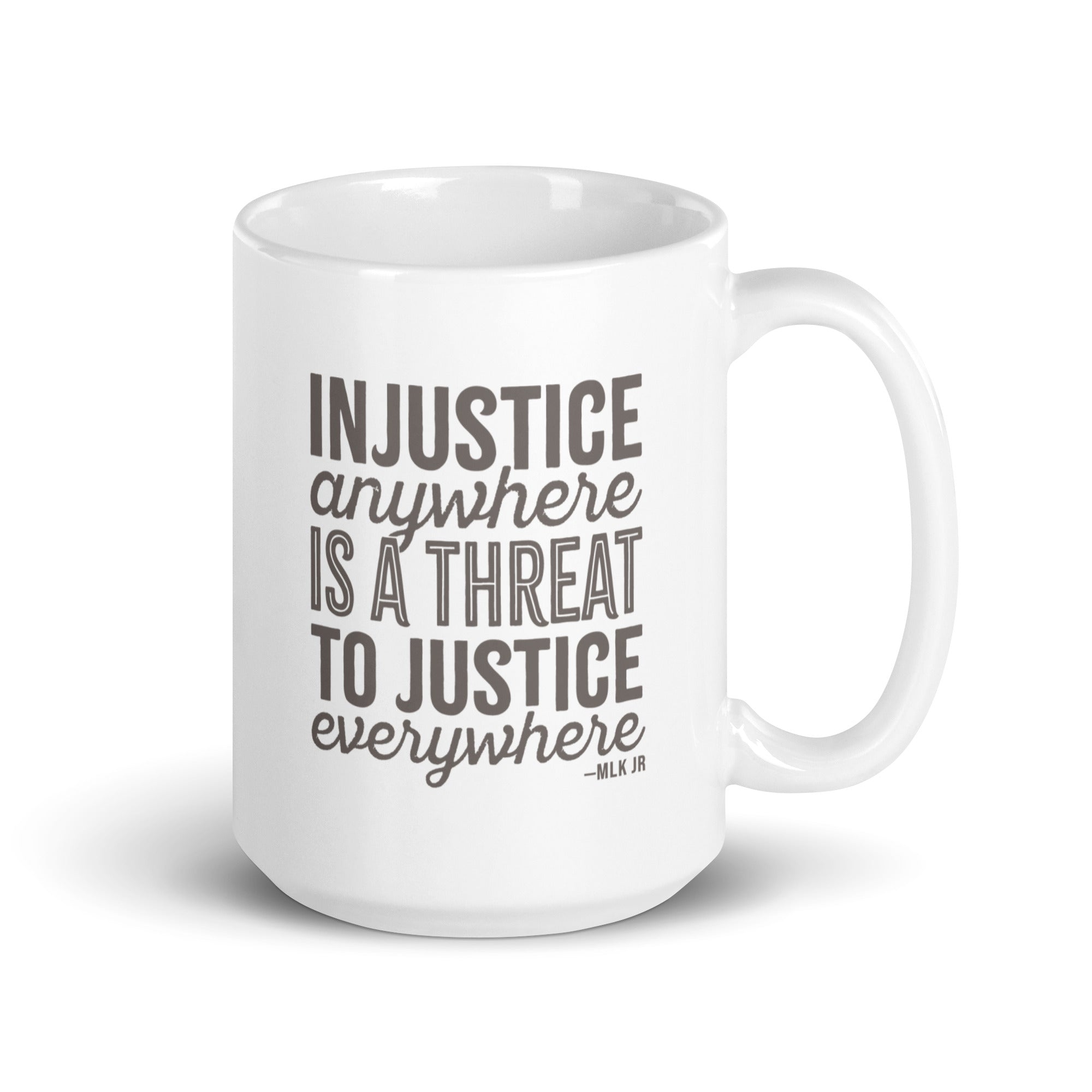 15 ounce white ceramic mug with bold text graphic reading “injustice anywhere is a threat to justice everywhere,” a quote from MLK Junior from Letters from Birmingham Jail.