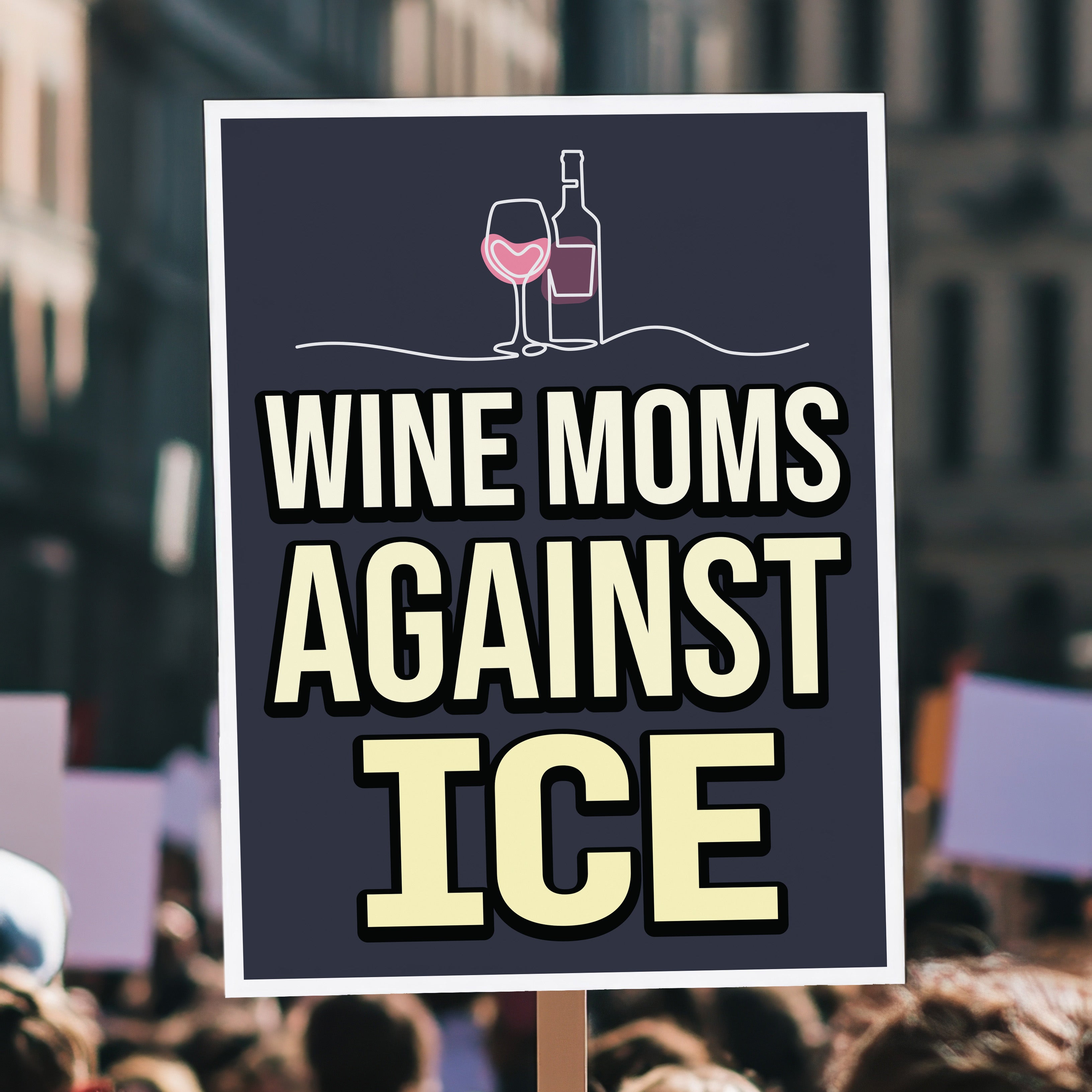 Protest sign held high above a crowd, reading “Wine Moms Against ICE” with a wine glass and bottle illustration, mocking Fox News claims about wine moms using Antifa tactics against ICE.