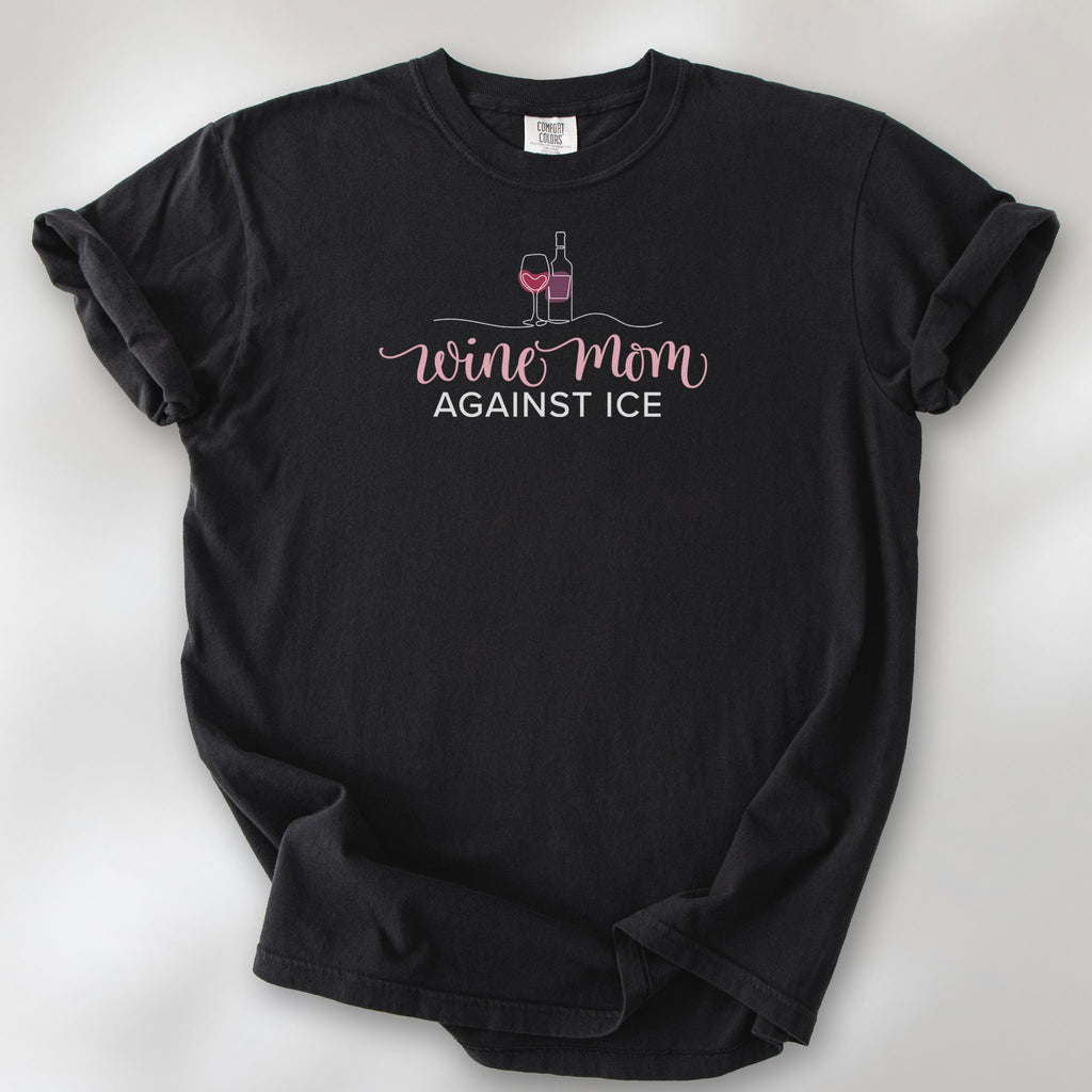 Black t-shirt featuring the text “Wine Mom Against ICE” with a minimalist illustration of a wine bottle and glass above the lettering.