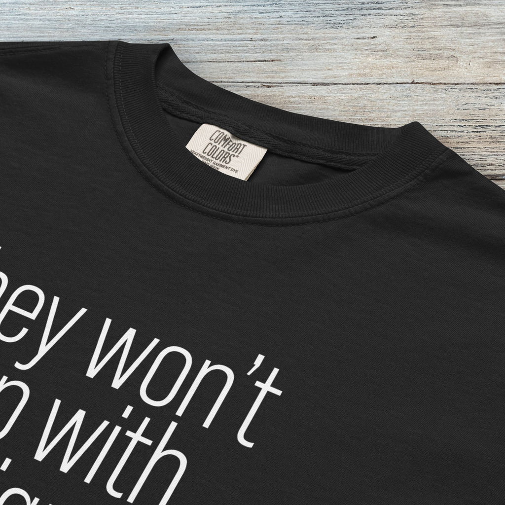 Closeup detail of black comfort colors tshirt with anti-ICE, anti-trump, anti-tyranny message that reads "they won't stop with immigrants."