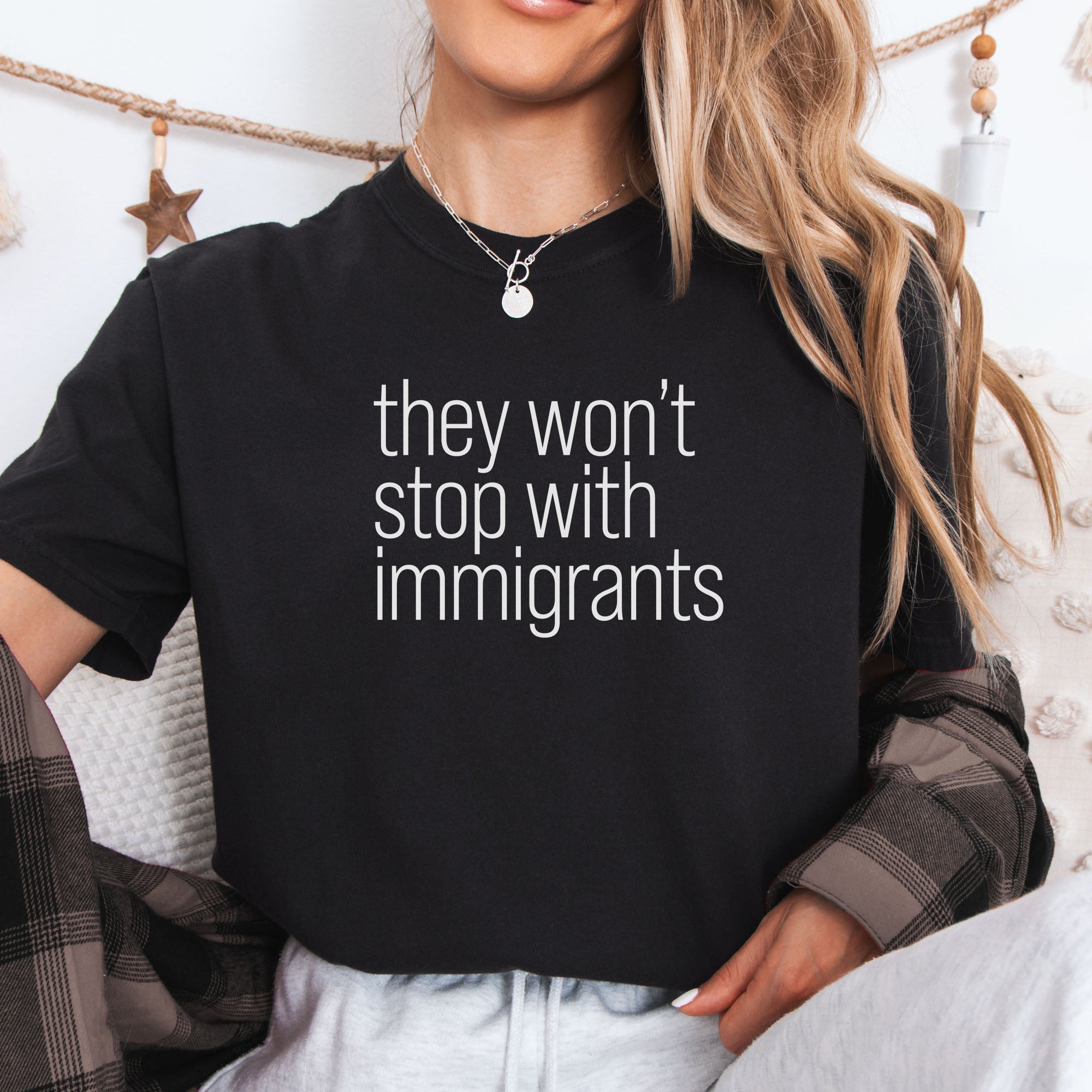 Female model wearing black comfort colors tshirt with anti-ICE, anti-trump, anti-tyranny message that reads 