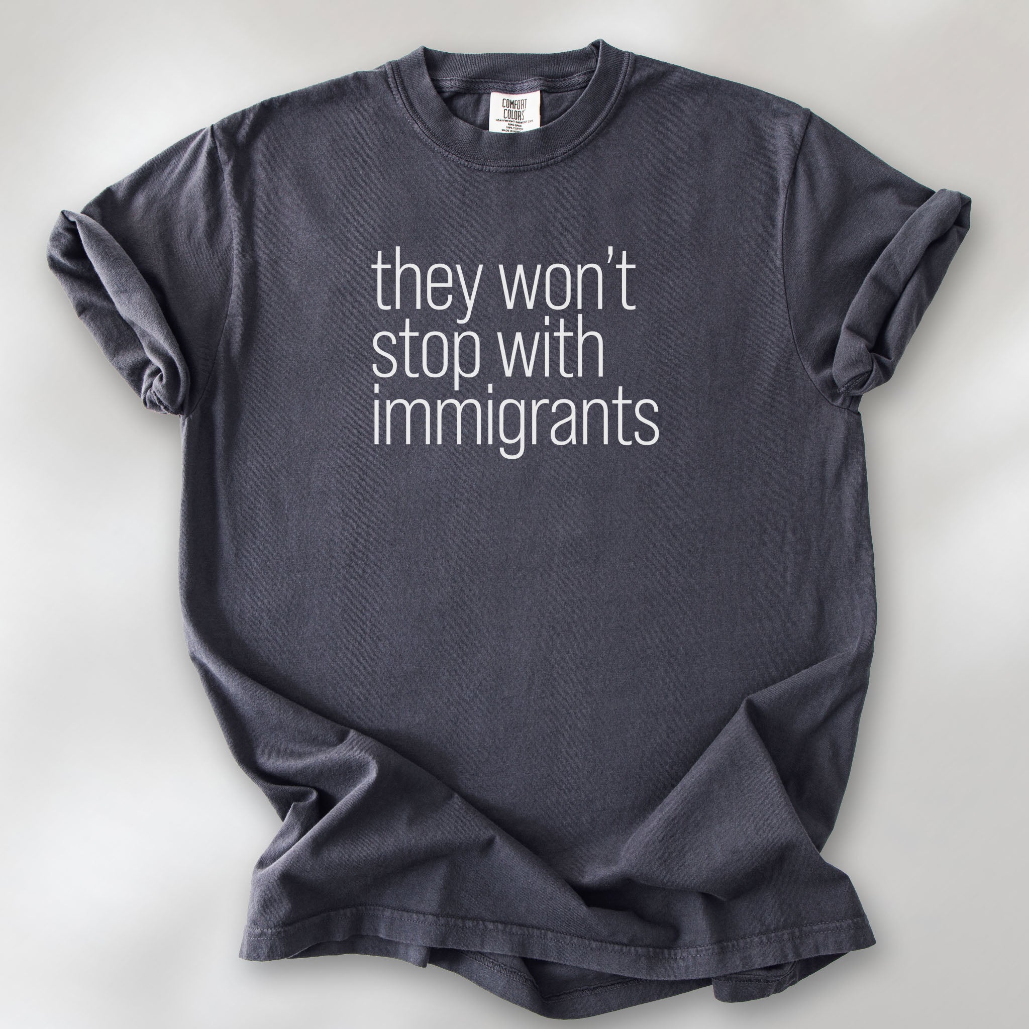 Graphite comfort colors tshirt with anti-ICE, anti-trump, anti-tyranny message that reads "they won't stop with immigrants."