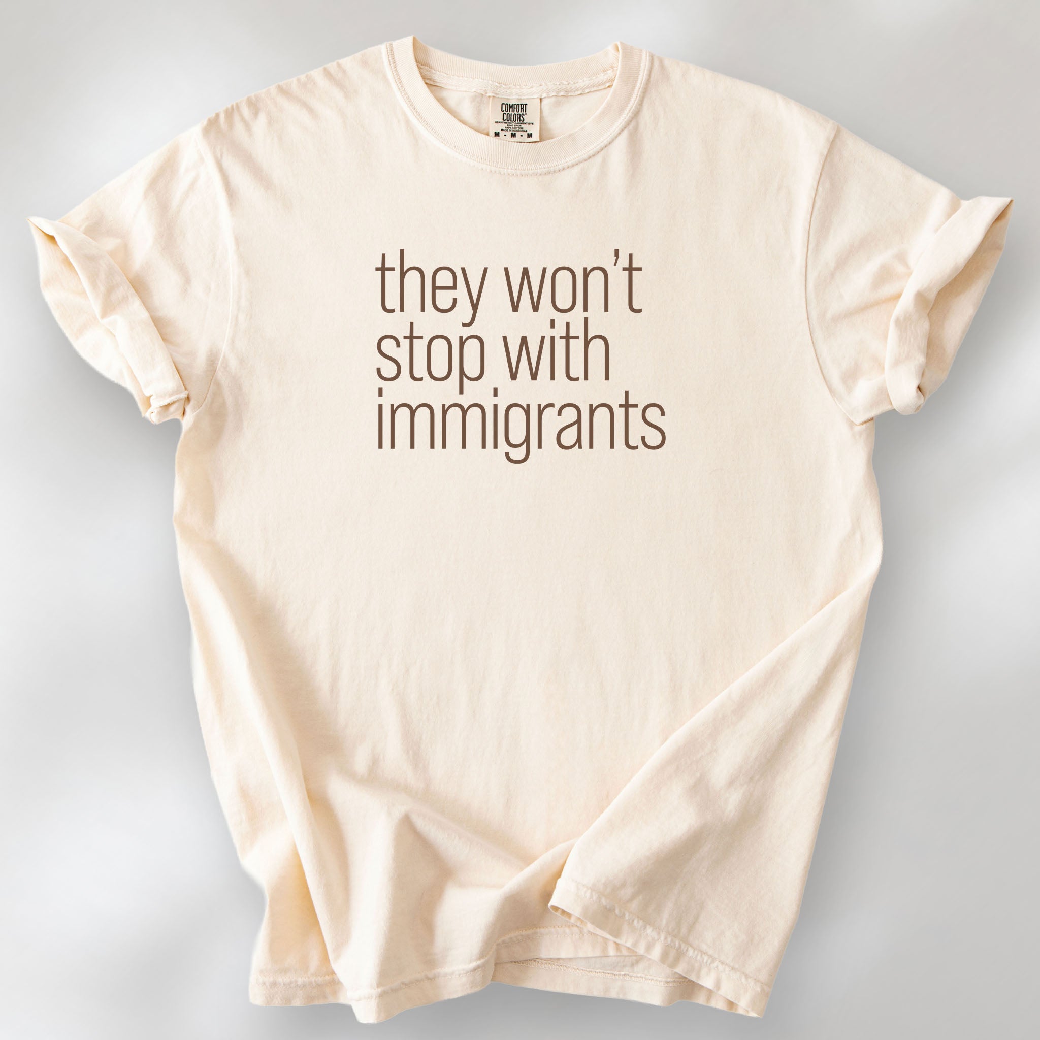 Ivory comfort colors tshirt with anti-ICE, anti-trump, anti-tyranny message that reads "they won't stop with immigrants."