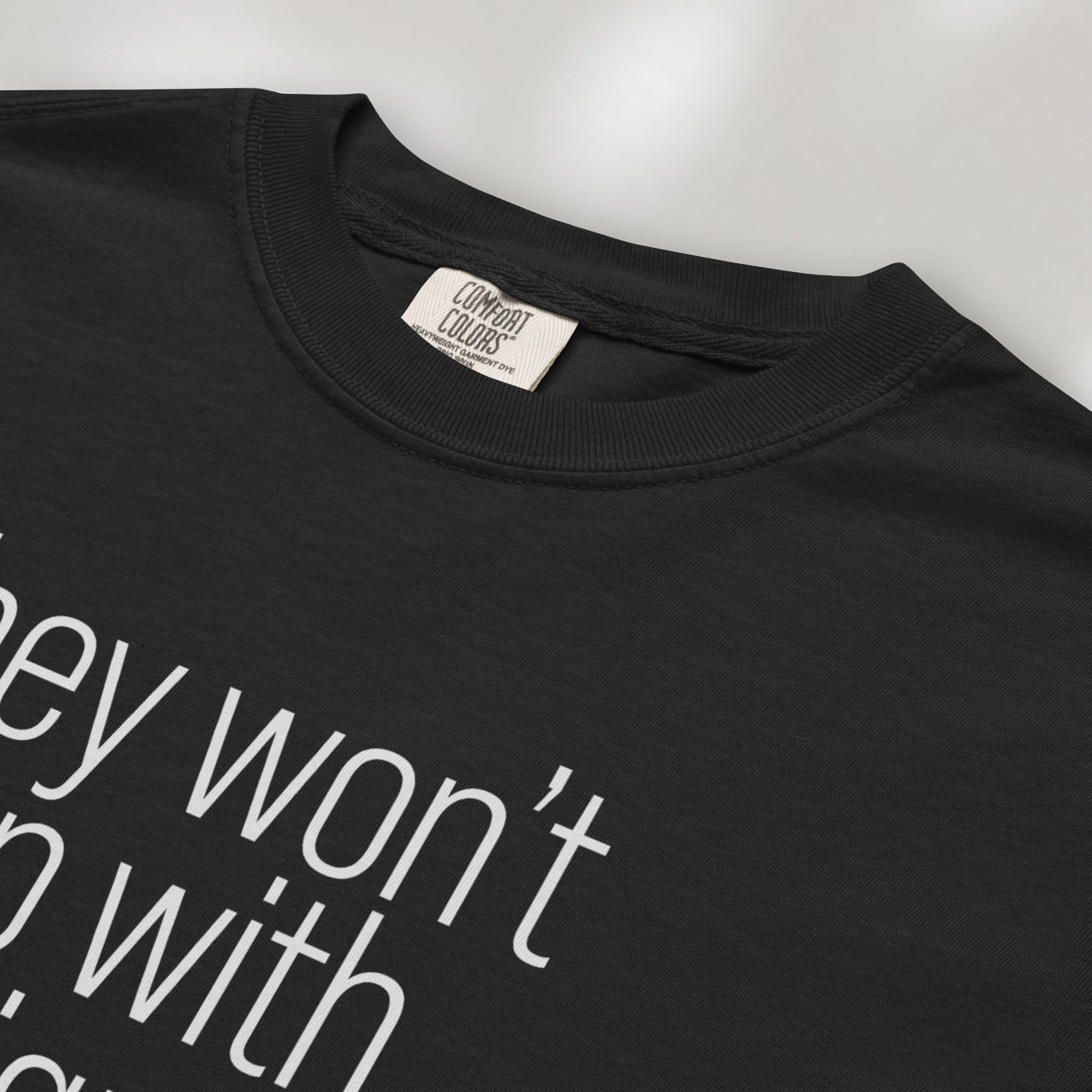 Closeup detail of black shirt with minimalist text that reads "they won't stop with immigrants."