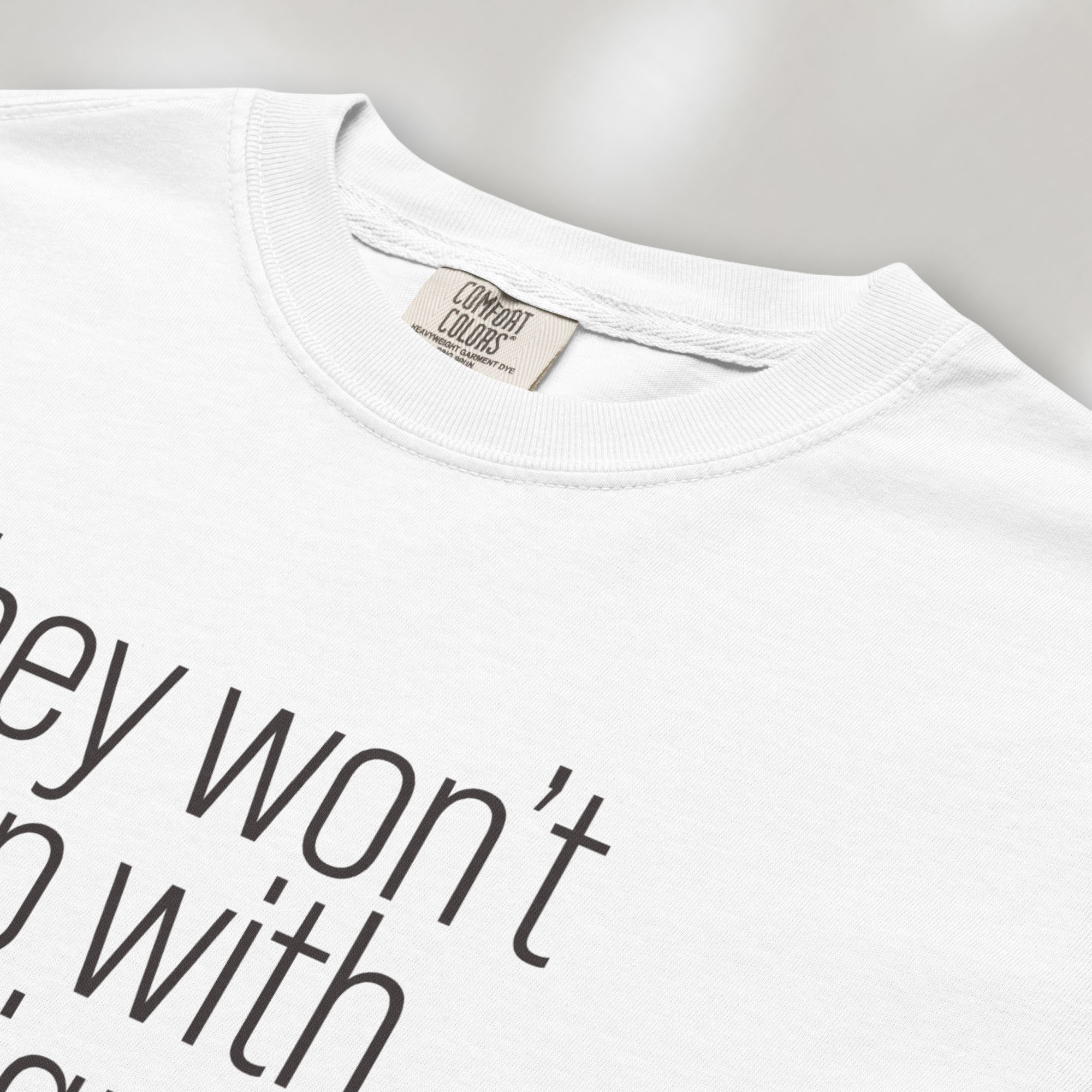 Closeup detail of white shirt with minimalist text that reads "they won't stop with immigrants."